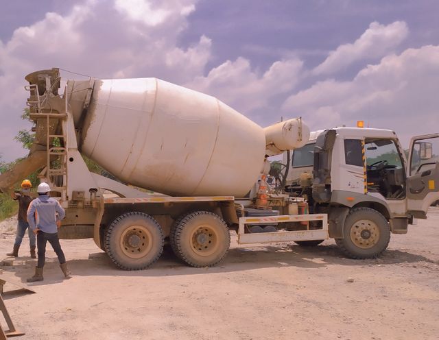 A cement mixer truck surreounded by workers prior to the traumatic brain injury